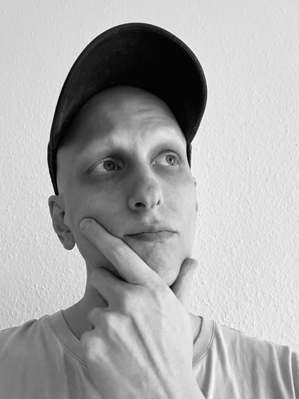 Daniel, who runs the coaching program, photographed against a plain wall